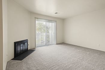 A room with a fireplace and carpeted floor.